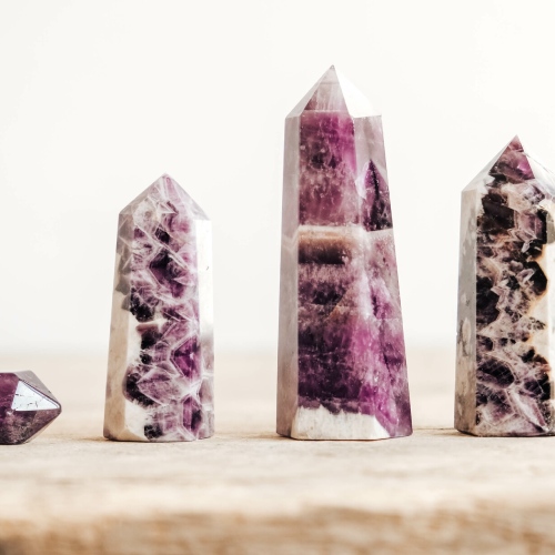 Pointes en pierre naturelle polie aux nuances violettes disposées sur fond clair
