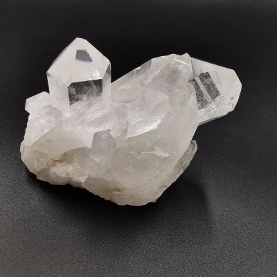 Pierre en bouquet de quartz naturel blanc avec cristaux bruts sur fond noir